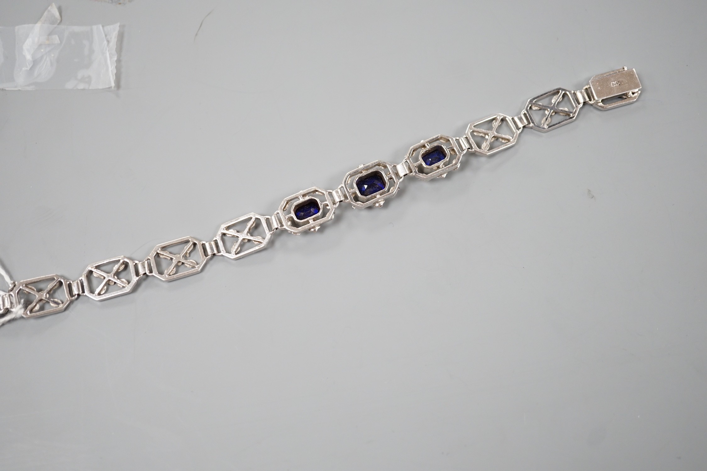 A modern 9ct white metal and three stone emerald cut sapphire set pierced link bracelet, approx. 18cm, gross weight 16.7 grams.
